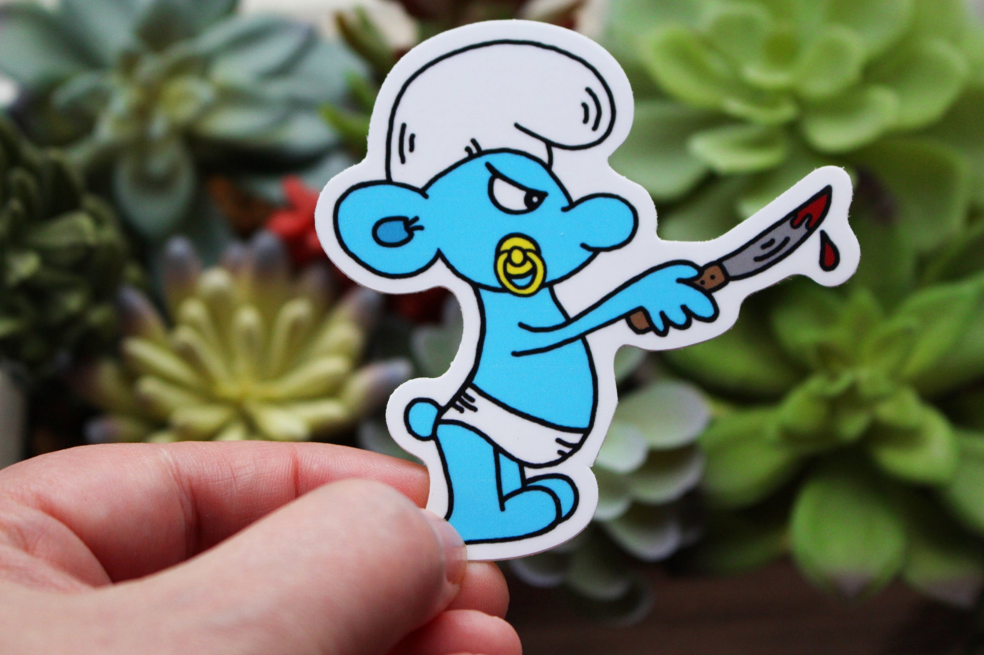 Baby Smurf Wearing a diaper sucking a pacifier holding a bloody knife sticker horror parody by SpookyKillerBabies.com